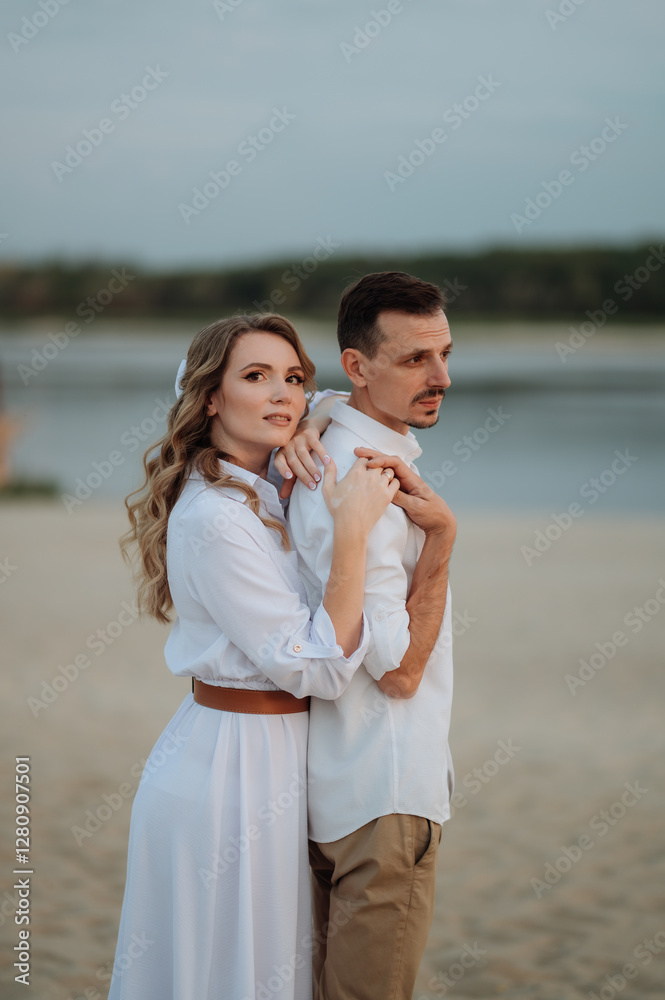 couple in love in white clothes hugging while standing on the shore, newlyweds, family relationships couple in love in white clothes hugging while standing on the shore, newlyweds, family relationships