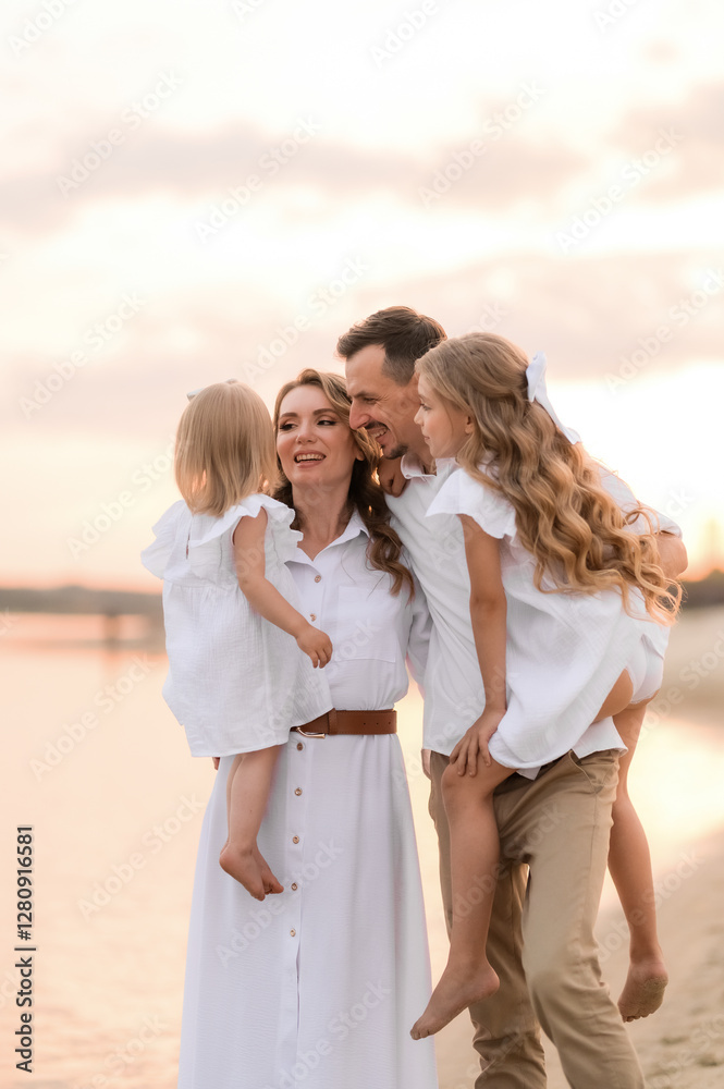 happy family with two children in white clothes walking on the river bank at sunset happy family with two children in white clothes walking on the river bank at sunset