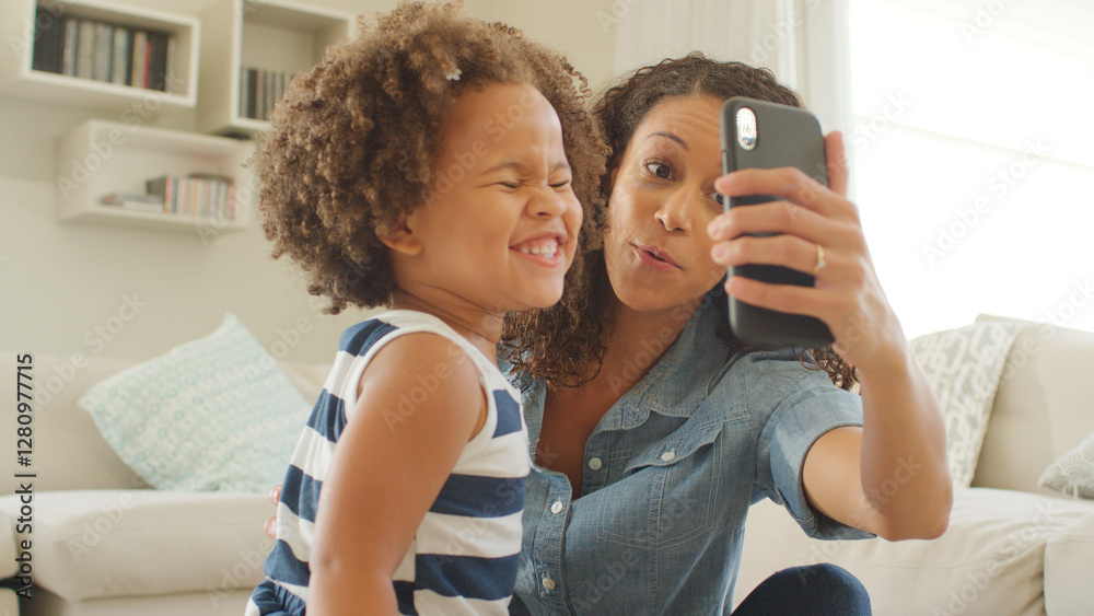 Mother Sits With Daughter At Home Taking Selfie On Mobile Phone Mother Sits With Daughter At Home Taking Selfie On Mobile Phone