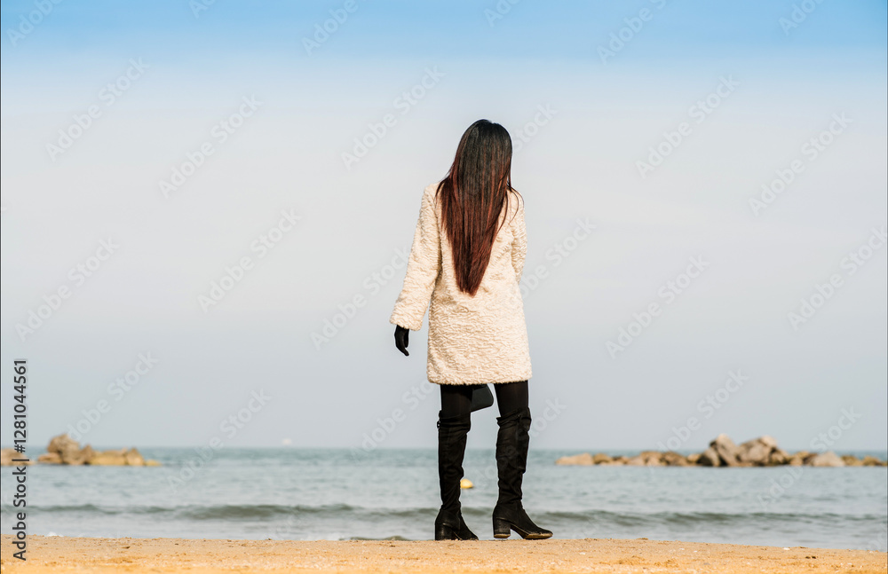 young woman walking along the beach young woman walking along the beach