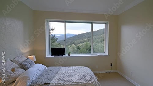 A bedroom with a panoramic view, soft-textured walls, and a discreet TV setup that blends seamlessly with the decor.