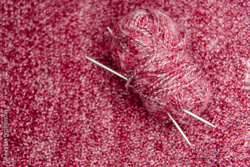 Close up of pink homemade knitted fabric with large stitches. Textured background