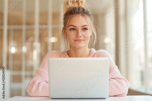 thoughtful young woman seated at desk with laptop gazing thoughtfully at screen in softly lit modern room representing