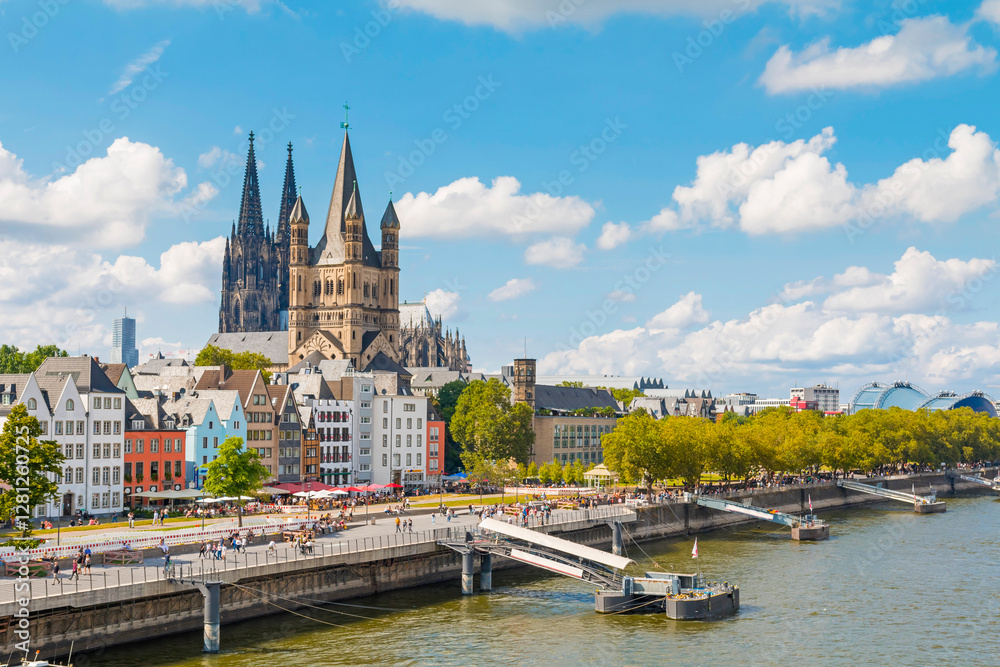 Fototapeta premium view of Cologne Cathedral and the Hohenzollern Bridge. The Gothic architecture of the cathedral contrasts beautifully with the iconic steel structure of the bridge.