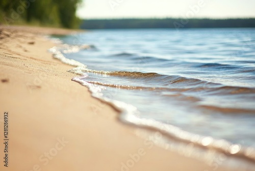 close-up of sandy beach with gentle waves lapping shore blurred horizon in background pure tranquility