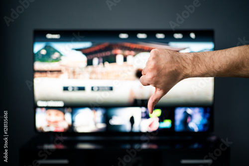 Bad movie stream service on tv. Thumbs down, dislike. Video on demand, VOD. Cancel subscription. Negative feedback. Series and film site online with expensive price. Watching television. Slow internet