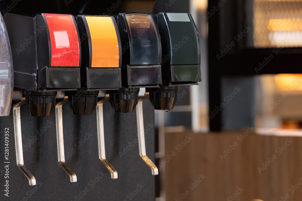 A row of soda dispensers with different colored tops A row of soda dispensers with different colored tops