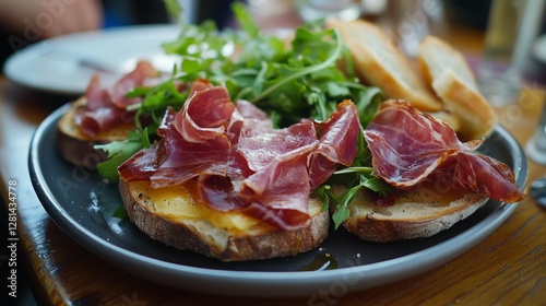 A plate of ham and cheese sandwiches with lettuce and spinach on top