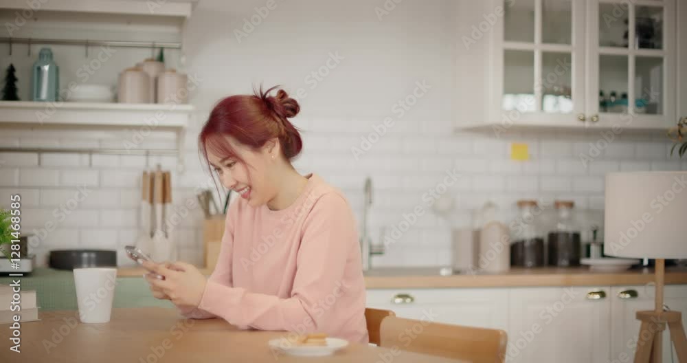 Smiling asian woman sitting in living room using cellphone texting, reading, sharing messages on social media. Relaxed female holding smartphone enjoy buying, ordering products online in apps at home. Smiling asian woman sitting in living room using cellphone texting, reading, sharing messages on social media. Relaxed female holding smartphone enjoy buying, ordering products online in apps at home.