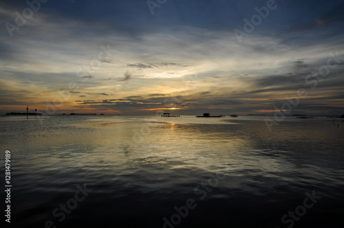 Water surface. View of a Sunset sky background. Dramatic gold sunset sky with evening sky clouds over the sea. 