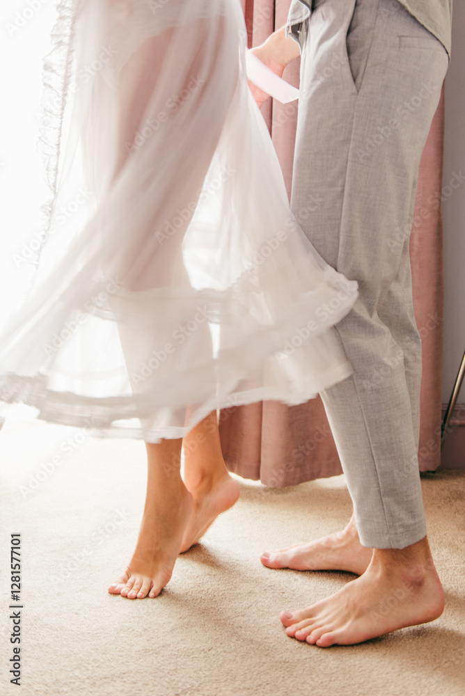 A romantic close-up of a bride and groom’s feet as they dance in an elegant hotel room, her flowing dress moving gracefully with each step. The soft lighting, vintage decor, and intimate atmosphere A romantic close-up of a bride and groom’s feet as they dance in an elegant hotel room, her flowing dress moving gracefully with each step. The soft lighting, vintage decor, and intimate atmosphere