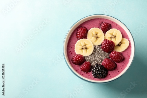 Colorful smoothie bowl topped with fresh bananas, raspberries, a