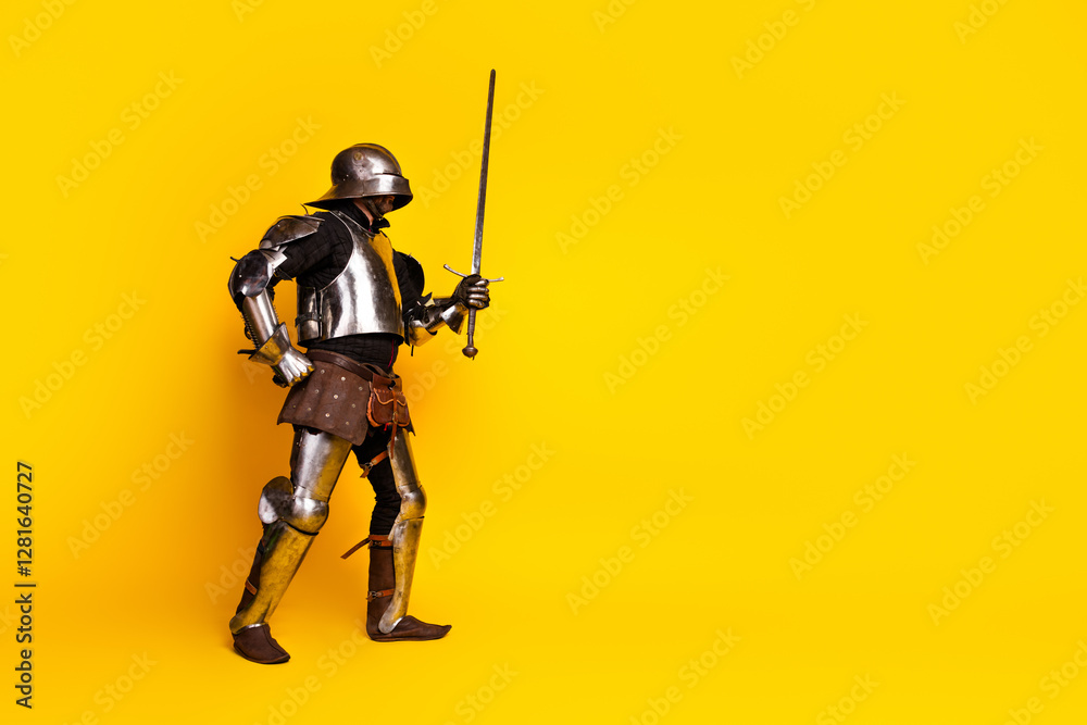 Medieval knight in full armor holding a sword with vibrant yellow background Medieval knight in full armor holding a sword with vibrant yellow background