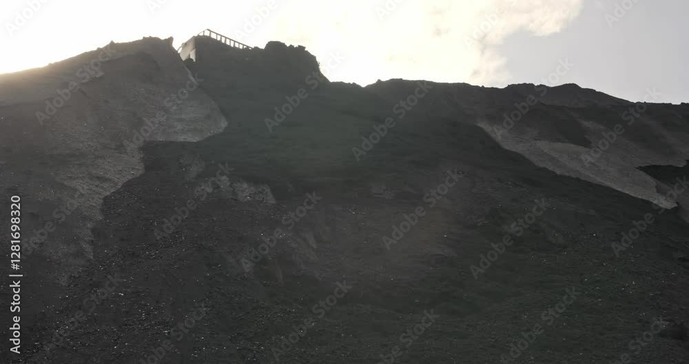 Wheel loader loads coal into wagons. Heavy machinery is working on coal loading at sorting site. Tractor shovels coal with bucket. Sorting and loading of Anthracite. Slow motion shipment coal