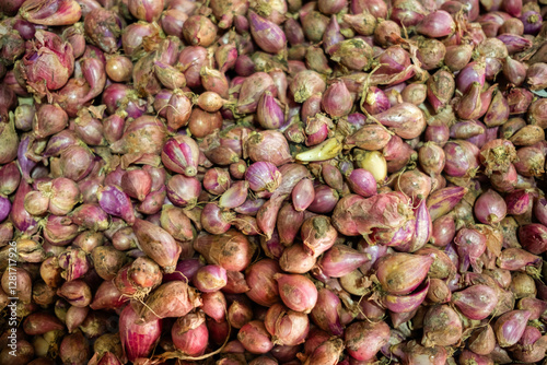 Fresh raw shallots (bawang merah) displayed, highlighting their small size, smooth reddish-purple skin, and strong aromatic flavor, commonly used in Asian cuisine photo