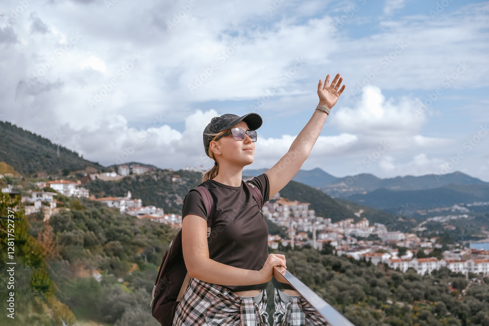 Naklejka premium Young woman embracing the freedom of solo travel and digital nomad lifestyle while enjoying a scenic mountain view. A symbol of adventure, independence, and modern exploration