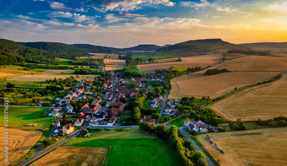 Vibrant German Village Nestled in a Valley Surrounded by Lush Greenery and Picturesque Mountains on a Bright Sunny Day