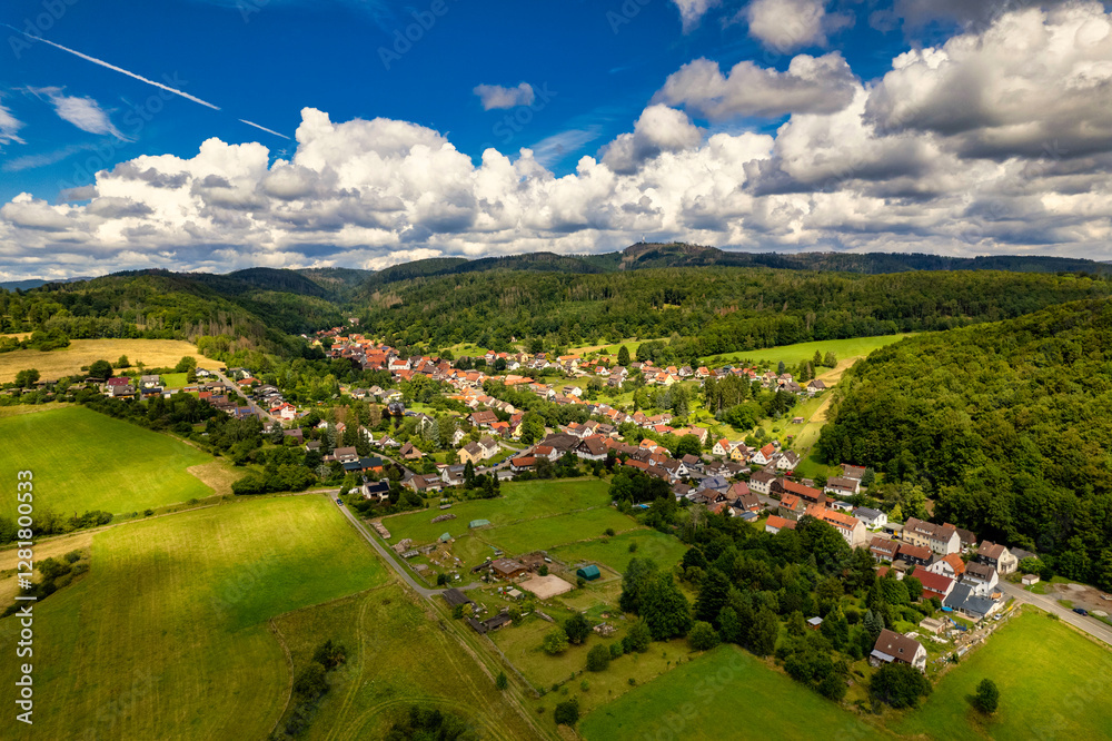 Vibrant German Village Nestled in a Valley Surrounded by Lush Greenery and Picturesque Mountains on a Bright Sunny Day