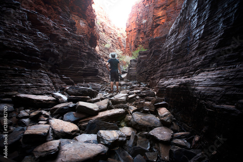 man standing on rocks in karijini gorge wearing hat Western Australia