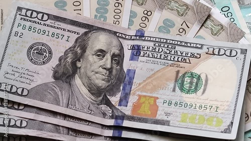 American one hundred dollar banknotes are placed on top of Indian rupees