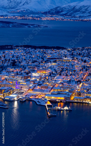 closeup aerial view of Tromsø at blue hour beautiful yellow lights, surrounded by dark blue sea