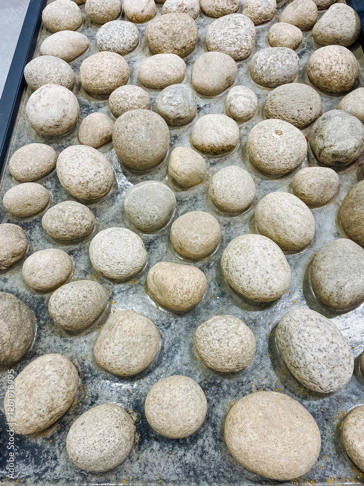 A collection of various rocks is stacked upon one another on a sturdy table, creating an interesting display that draws attention and curiosity from anyone who happens to see it