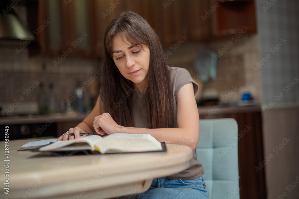 Female student learning and preparing exam at home. Woman reading textbook and taking notes