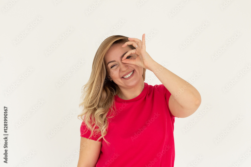 Beautiful young woman wearing casual red t-shirt doing ok gesture with hand smiling, eye looking through fingers with happy face.