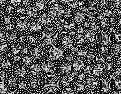 seamless hand drawn small dense polkadot animal spots pattern in white on black background abstract aboriginal dot art motif or organic cellular texture in a trendy doodle line art or linocut style