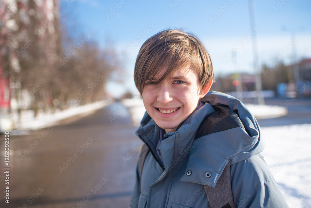 portrait of a schoolboy, boy, teenager in a gray jacket without a hat on a sunny day in winter outside portrait of a schoolboy, boy, teenager in a gray jacket without a hat on a sunny day in winter outside