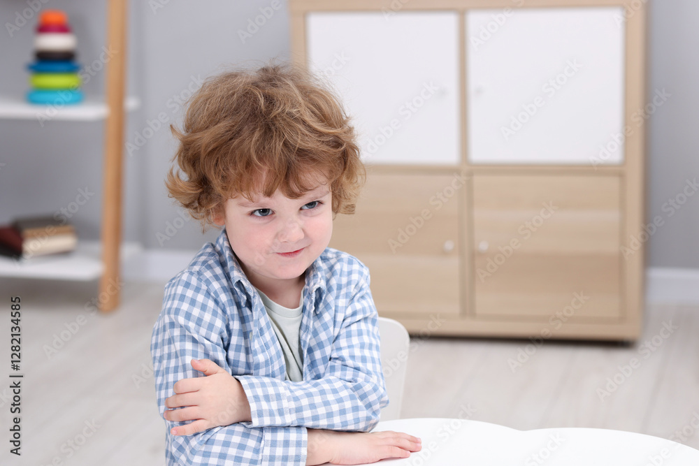 Resentful little boy at white table indoors, space for text Resentful little boy at white table indoors, space for text