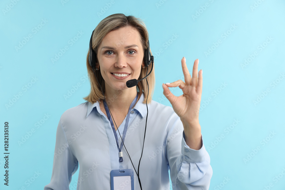 Technical support call center. Smiling operator showing ok gesture on light blue background Technical support call center. Smiling operator showing ok gesture on light blue background