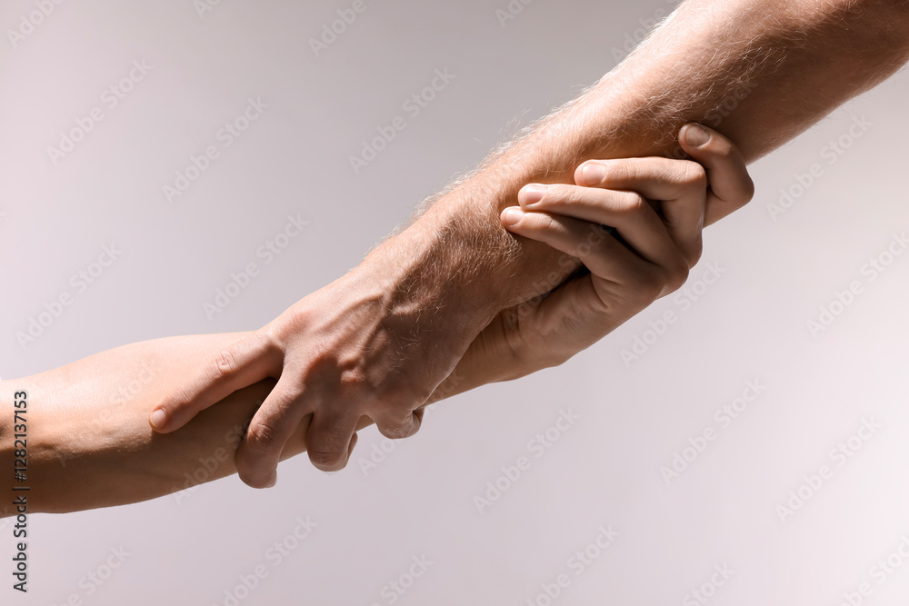 Help and support. People holding hands on light grey background, closeup Help and support. People holding hands on light grey background, closeup