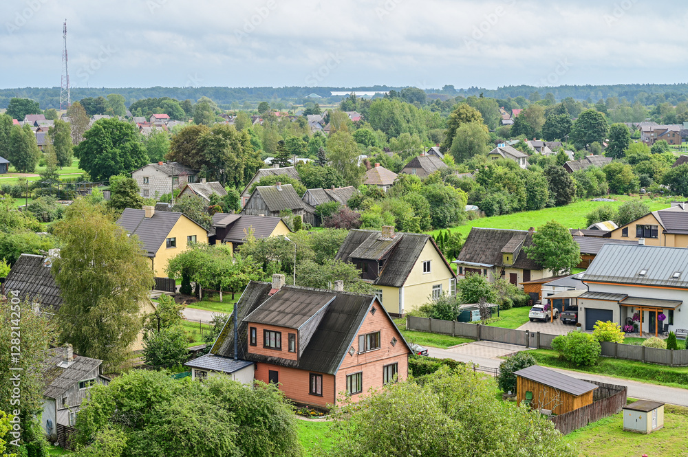 Obraz premium Panoramic view of the historic town of Kuldiga, featuring houses, streets, trees, and fields in a summer landscape, Kurland, Latvia