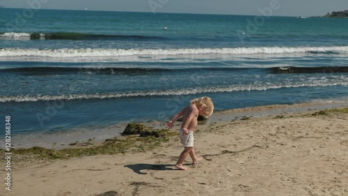 Wallpaper Mural On beautiful warm day, carefree child joyfully explores shoreline, happily playing near gentle waves, capturing pure innocence of childhood amidst natures stunning beauty Torontodigital.ca