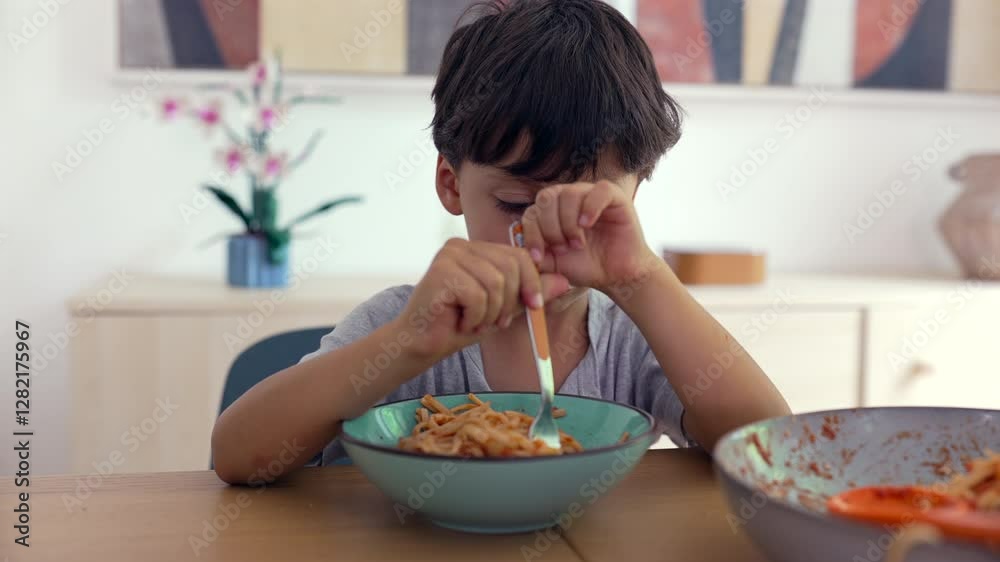 Young boy eating spaghetti with bored expression, slow chewing, neutral reaction to meal, childhood dining habits, home-cooked food, everyday routine at the table Young boy eating spaghetti with bored expression, slow chewing, neutral reaction to meal, childhood dining habits, home-cooked food, everyday routine at the table