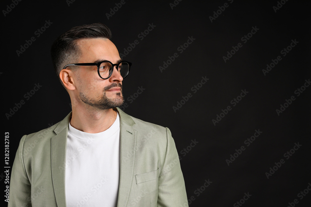Obraz premium Portrait of handsome middle aged man on black background, space for text