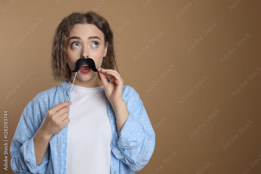 Woman with fake paper mustache on beige background. Space for text Woman with fake paper mustache on beige background. Space for text
