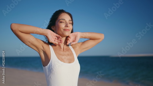 Woman enjoying marine nature raising hands to clear sky on sunny beach closeup.