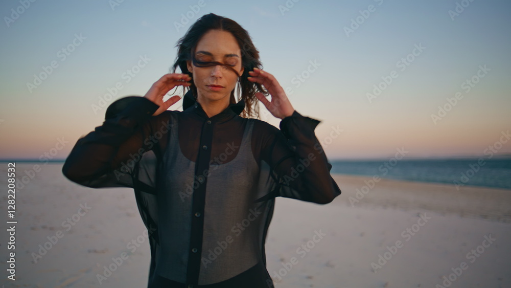 Girl enjoy windy ocean shore at evening closeup. Lonely woman at beach sunset Girl enjoy windy ocean shore at evening closeup. Lonely woman at beach sunset