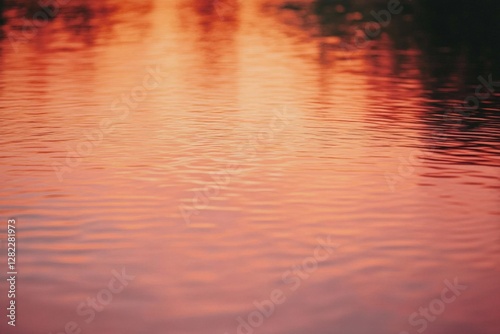 Obraz na płótnie Water surface reflecting orange and pink hues during sunset at a calm lake in a serene natural setting w salonie