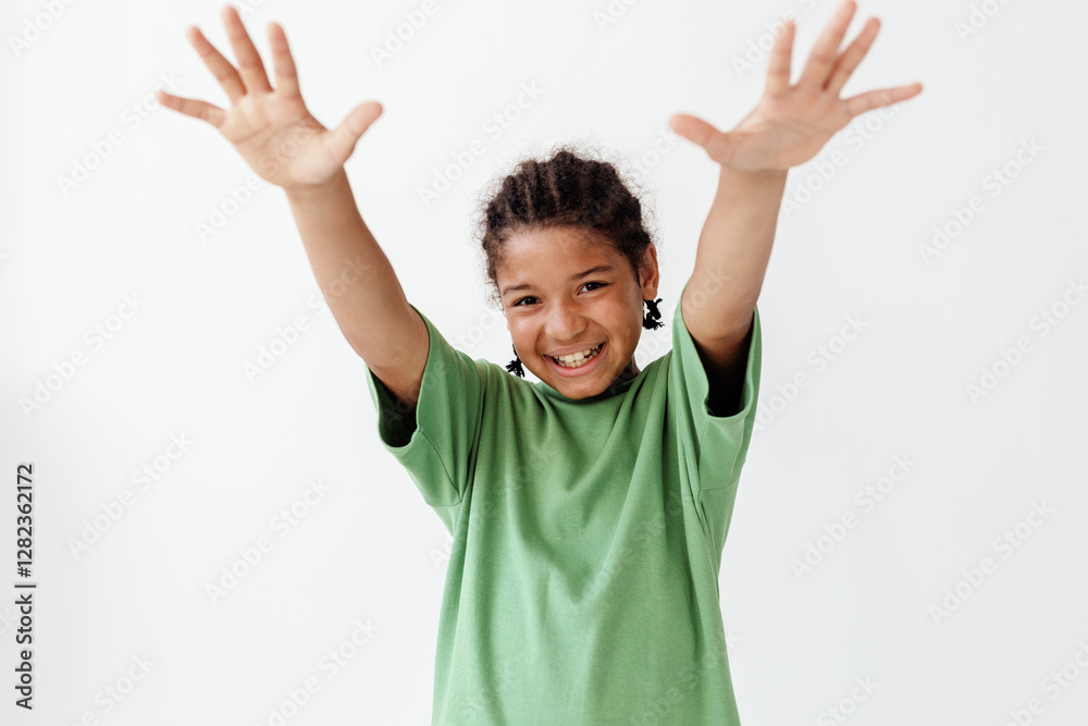 Excited young boy in green tshirt raising hands in trendy celebration pose Excited young boy in green tshirt raising hands in trendy celebration pose