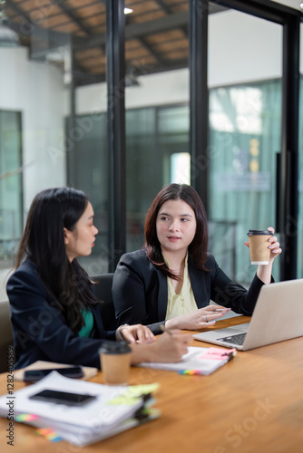 Professional women brainstorming project ideas and discussing strategies in a vibrant office environment.