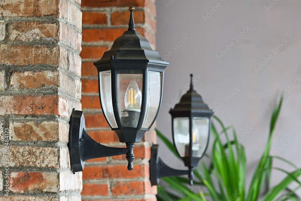 Photo of lamp light on the brick wall. Vintage iron lantern on the wall outdoor. Garden metal electrical lamp on the cafe or coffee shop. Wall lamp outdoor. Photo of lamp light on the brick wall. Vintage iron lantern on the wall outdoor. Garden metal electrical lamp on the cafe or coffee shop. Wall lamp outdoor.