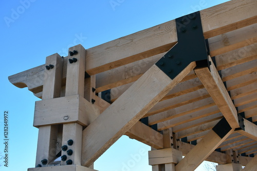 Gazebo in city park. Large wooden beams with metal brackets.