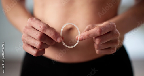 Young woman smiling holding diaphragm vaginal contraceptive ring