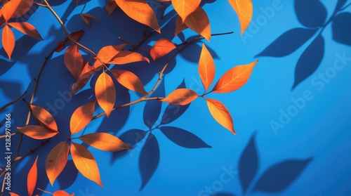 Abstract shadow play of orange leaves on a vibrant blue background ideal for creative designs, wall art, and modern presentations.