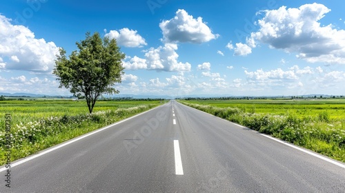 Open Road Through Green Fields Under Sunny Sky. Possible Use Stock photo for travel, adventure, or nature themes