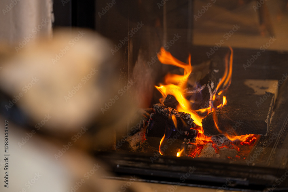 Fireplace. A warm and inviting fireplace with burning logs and flickering flames, creating a cozy atmosphere perfect for relaxation during cold winter days. Selective focus.