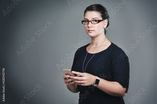 Phone, portrait and creative with business woman in studio for virtual stylist, fashion consultant and client briefing. Costume designer, wardrobe assistant and contact with person on gray background photo